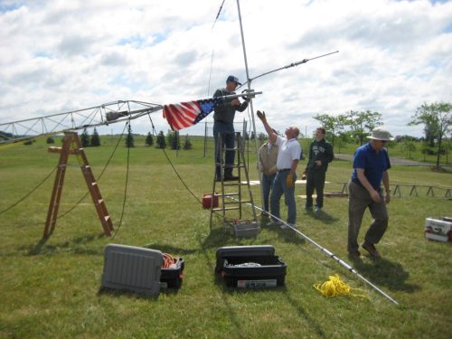 N8AR fastening the 10-15-20 meter antenna choke to the tower while KD8OSM gives encouragement